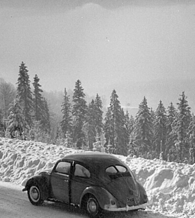 Oldtimer steht geparkt am Rande einer verschneiten Straße