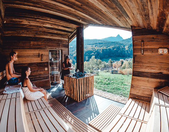 Geräumige Holzsauna im Außenbereich des Wellnesshotels mit direkten Blick auf das Berchtesgadener Land