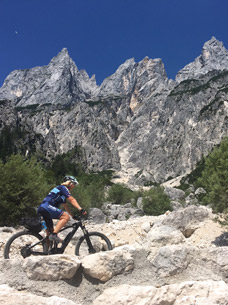 Eine Frau macht eine Radtour durch das Bertesgadener Land vorbei an beeindruckenden Gipfeln