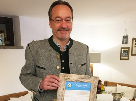 Johannes Lichtmanegger präsentiert stolz die Auszeichnung "Klimapositiv"