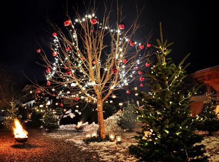 Weihnachtlich mit Lichterketten und Christbaumkugeln behangene Bäume