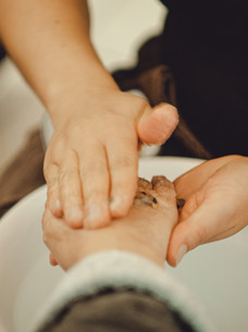 Frau lässt sich im Spa Hotel in Berchtesgaden die Hände mit einem Peeling einreiben