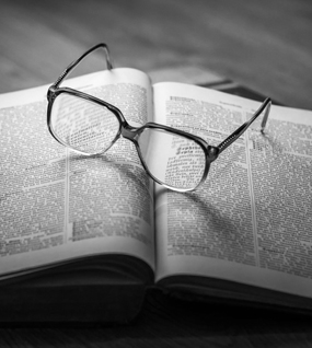 Hornbrille liegt auf einem geöffneten Buch