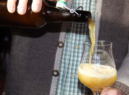 Bier wird aus einer braunen Flasche in ein Glas gefüllt