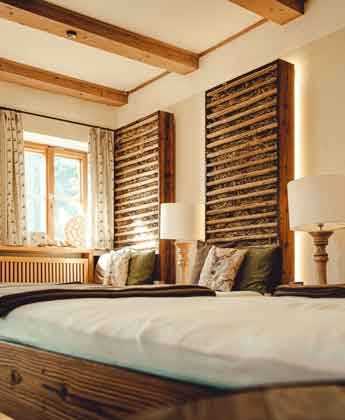 Zwei Holzliegen mit Kissen und Decke im Ruheraum des Wellnesshotel in Berchtesgaden